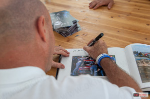 Biasion firma un libro fotografico che lo ritrae